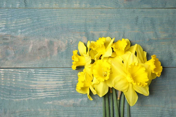 Buquê de narcisos sobre fundo de madeira, vista superior com espaço para texto. Flores frescas da primavera — Fotografia de Stock