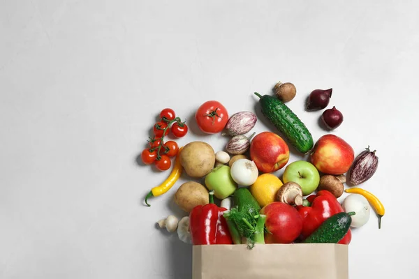 纸袋用新鲜蔬菜和水果在浅色背景上，平躺。文本空间 — 图库照片