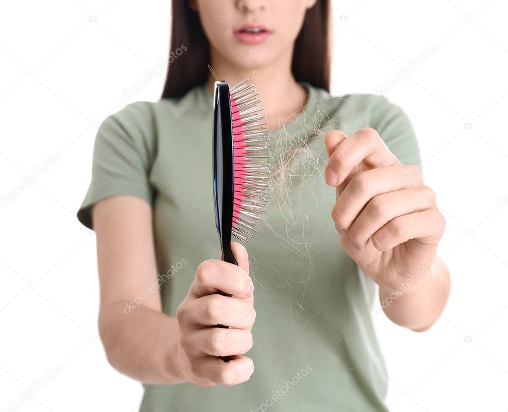 Young woman with brush on white background, closeup. Hair loss problem