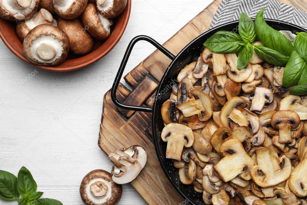 Flat lay composition with delicious cooked mushrooms on table