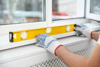 Süre installing pencere kapalı, closeup kabarcık düzeyi kullanarak inşaat işçisi