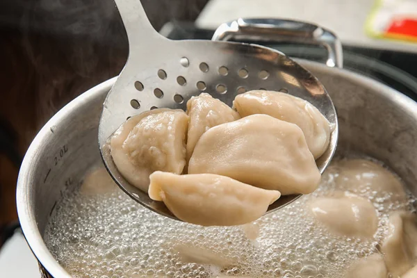 Close-up van knoedels op Skimmer over stewpan met kokend water. Thuis koken — Stockfoto