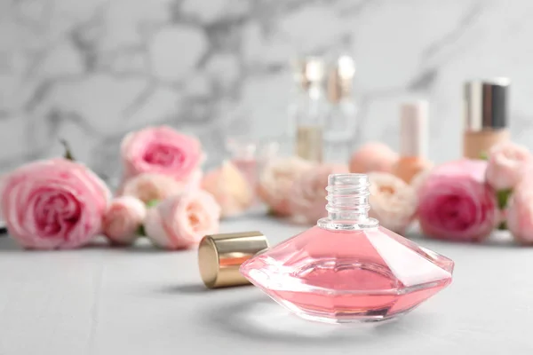 Eine Flasche Parfüm und Rosen auf dem Tisch vor Marmorhintergrund. Raum für Text — Stockfoto