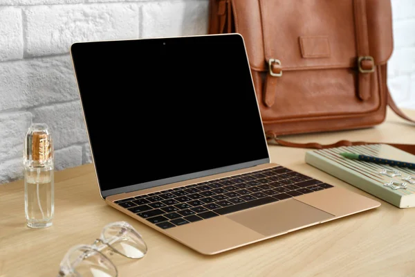 Elegante lugar de trabajo con portátil moderno en la mesa cerca de la pared de ladrillo. Blogger de moda —  Fotos de Stock