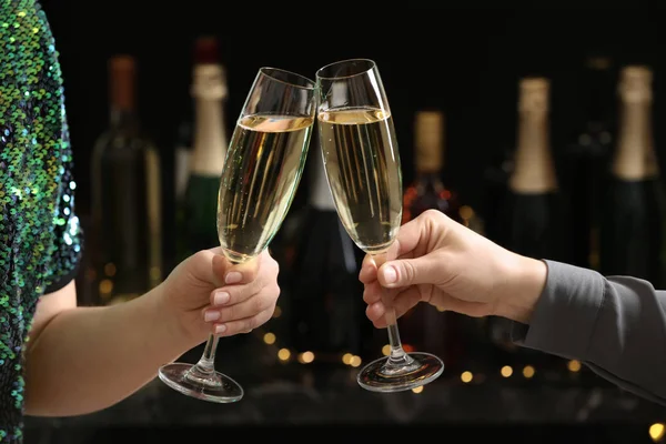 People clinking glasses of champagne on blurred background, closeup