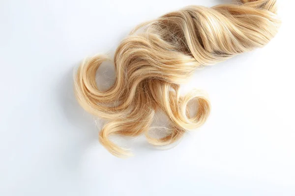 Schöne lockige blonde Haare auf weißem Hintergrund, Draufsicht. Friseurservice — Stockfoto