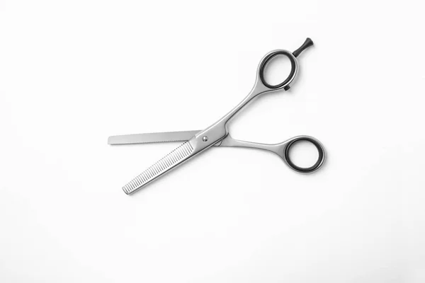 New thinning scissors on white background, top view. Professional hairdresser tool