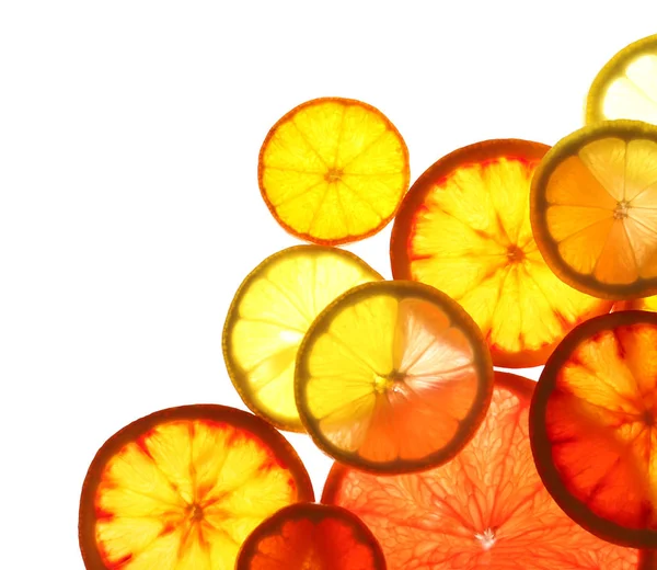 Illuminated slices of citrus fruits on white background, top view — Stock Photo, Image