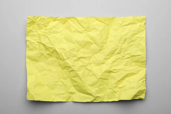 Color sheet of crumpled paper on grey background, top view — Stock Photo, Image