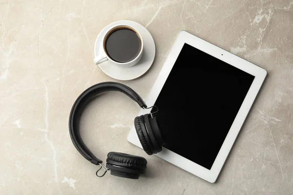 Επίπεδη σύνθεση με ακουστικά, tablet και φλιτζάνι καφέ στο τραπέζι. Χώρος για κείμενο — Φωτογραφία Αρχείου