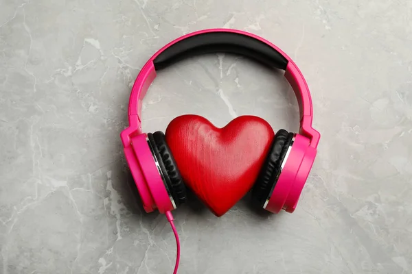 Decoratief hart met moderne koptelefoon op kleur achtergrond, bovenaanzicht — Stockfoto