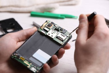 Teknisyen masada cep telefonu tamir, closeup. Cihaz onarım hizmeti