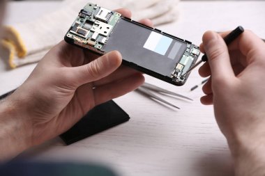 Teknisyen masada cep telefonu tamir, closeup. Cihaz onarım hizmeti