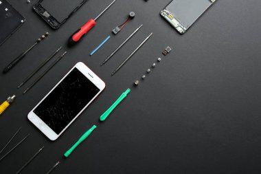 Kırık cep telefonu ve onarım araçları renkli arka plan, düz yatıyordu. Metin için alan