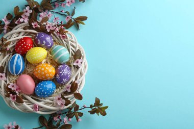 Boyalı Paskalya yumurtaları ve renk arka plan üzerinde çiçek dalları ile Düz yatıyordu kompozisyon, metin için alan