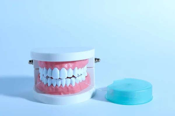Zęby typodont i nici na kolorowym tle, miejsce na tekst. Konsultacje z dentystą — Zdjęcie stockowe