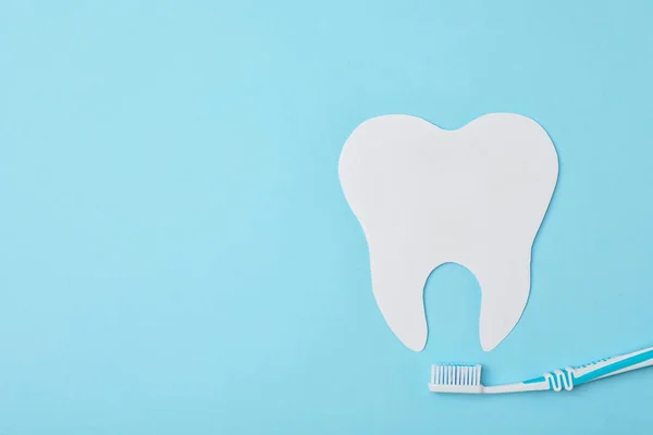 Papierzahnausschnitt und Pinsel auf farbigem Hintergrund, flache Lage mit Platz für Text. professioneller Zahnarzt — Stockfoto