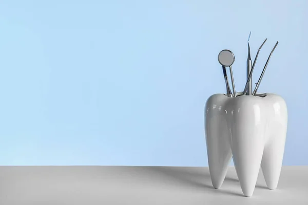 Tooth shaped holder with professional dentist tools on grey background. Space for text — Stock Photo, Image