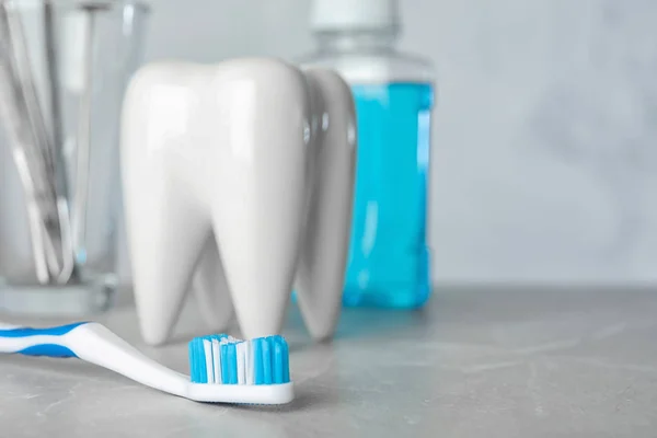 Escova e suporte em forma de dente na mesa, espaço para texto. Dentista profissional — Fotografia de Stock