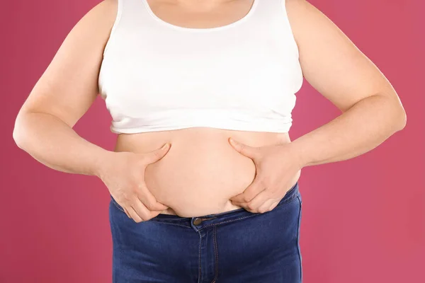 Overgewicht vrouw op kleur achtergrond, close-up. Obesitas en gewichtsverlies — Stockfoto