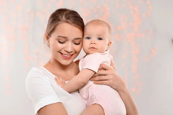 Ritratto di madre felice con il suo bambino contro le luci sfocate — Foto Stock