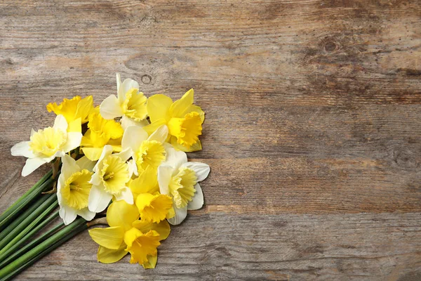 Ramillete de narcisos sobre fondo de madera, vista superior con espacio para texto. Flores frescas de primavera — Foto de Stock