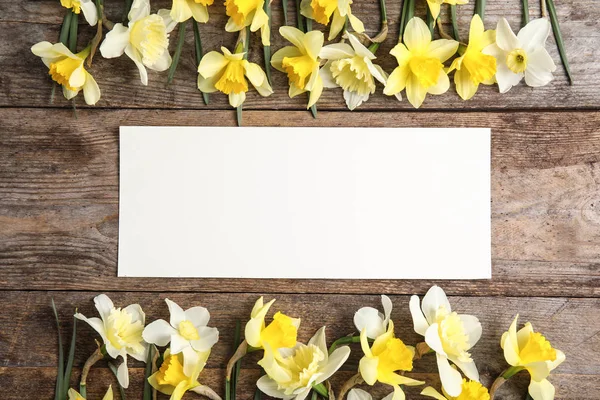 Composición plana con narcisos y espacio para texto sobre fondo de madera. Flores frescas de primavera — Foto de Stock