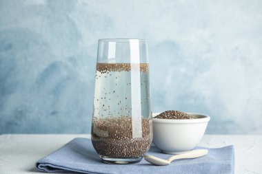 Renk arka plan karşı masada su ve chia tohumu cam ile Kompozisyon