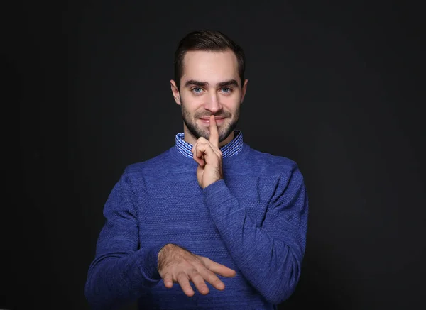 Hombre mostrando gesto de HUSH en lenguaje de señas sobre fondo negro — Foto de Stock