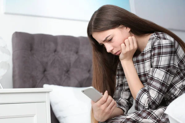 Aufgebrachte Teenager mit Smartphone im Bett. Raum für Text — Stockfoto