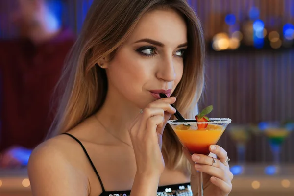 Красивая молодая женщина со стаканом мартини в баре — стоковое фото