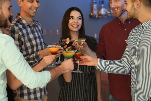 Grupo de jovens segurando coquetéis martini na festa — Fotografia de Stock