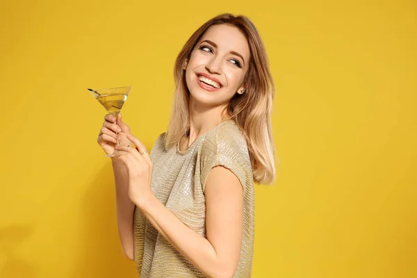 Belle jeune femme avec verre de cocktail martini sur fond de couleur — Photo