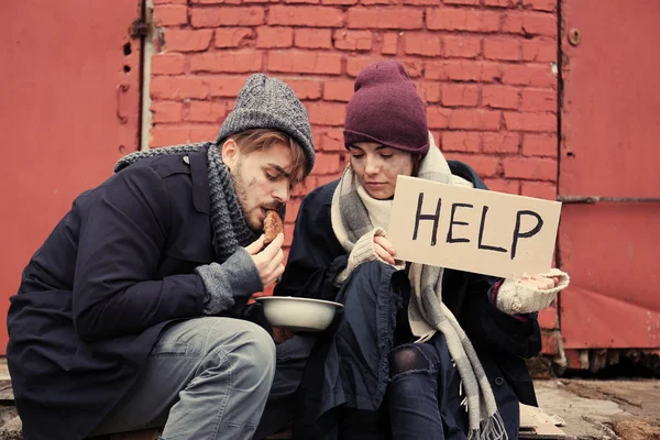 Pobre jovem casal com sinal AJUDA e pão na rua suja — Fotografia de Stock
