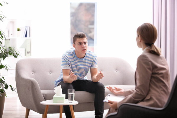 Psychotherapist working with young man in office