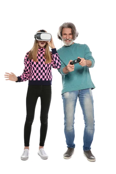 Adolescente vestindo fone de ouvido VR e homem maduro com controlador jogando jogos de vídeo no fundo branco — Fotografia de Stock