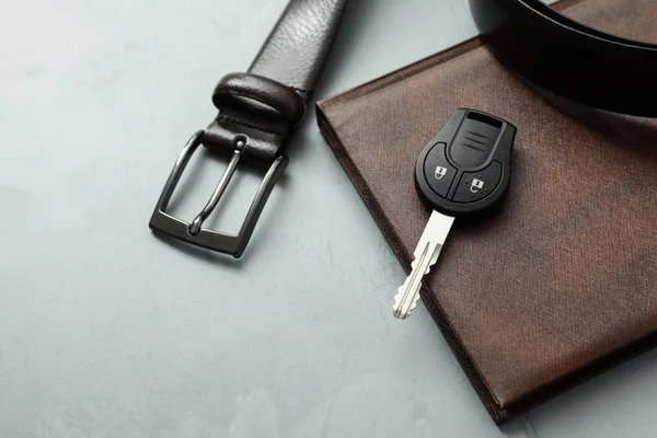 Composição com acessórios masculinos e chave do carro no fundo cinzento — Fotografia de Stock