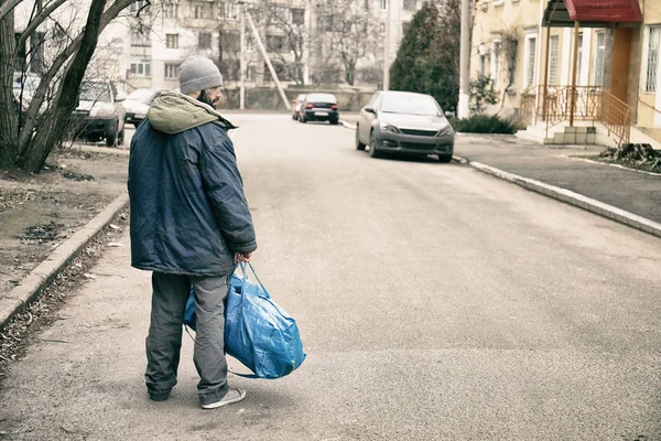 Pobre sem-teto com saco na rua da cidade — Fotografia de Stock