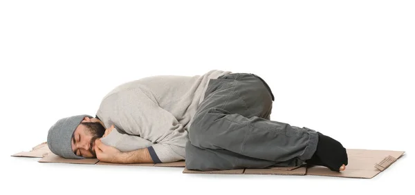 Poor homeless man lying on cardboard, white background — Stock Photo, Image