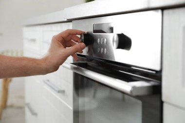 Erkek mutfakta fırın panelinde pişirme modu düzenleyen, çekim