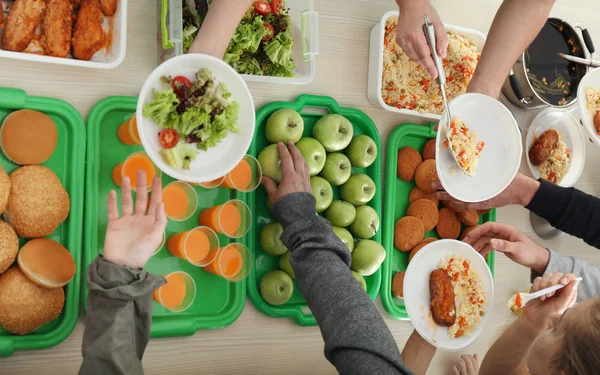 Volunteers serving food for poor people indoors, view from above — Stock Photo, Image