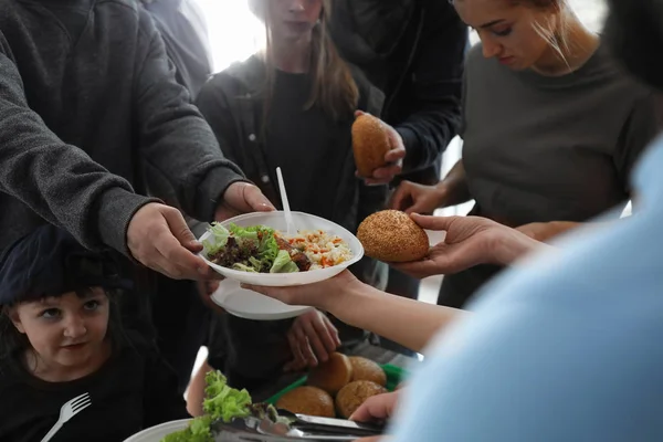 Pobres recibiendo comida de voluntarios en el interior, primer plano — Foto de Stock