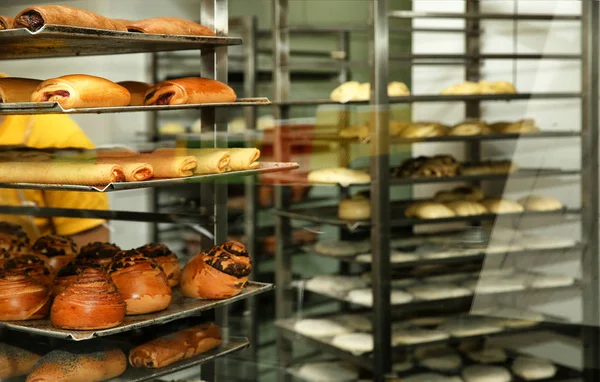 Rack with fresh pastries in bakery workshop — Stock Photo, Image