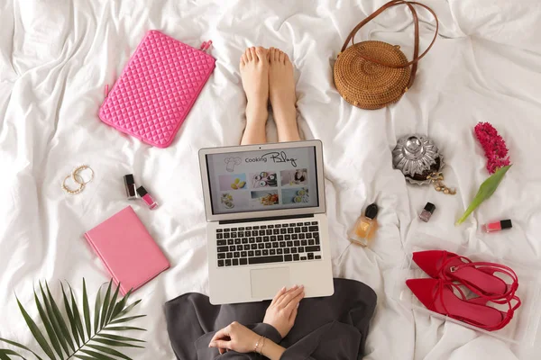 Mulher e laptop com blog de culinária aberta na cama, vista superior — Fotografia de Stock