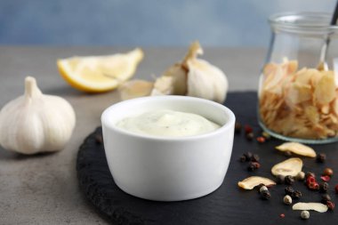Composition with garlic sauce on grey table clipart