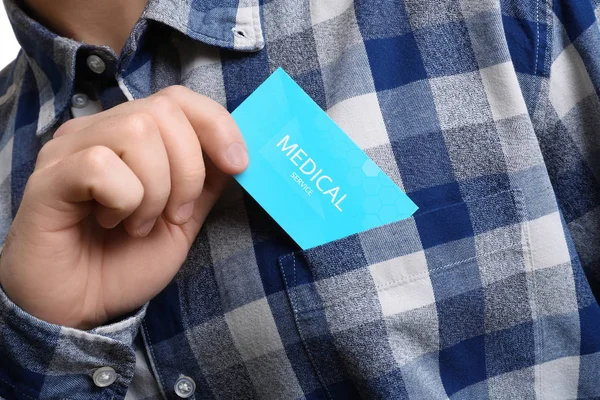 Hombre poniendo la tarjeta de visita en el bolsillo, primer plano. Servicio médico — Foto de Stock