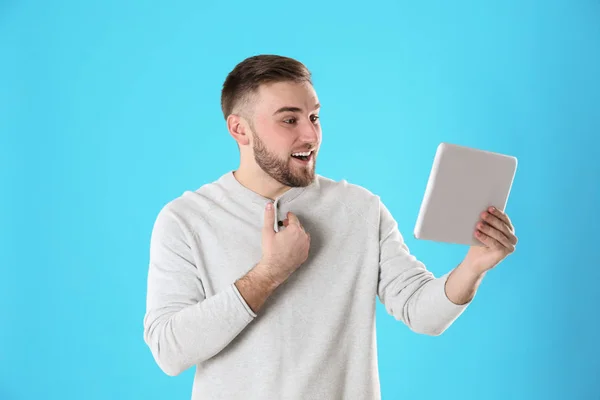 Jonge man met behulp van video-chat op Tablet tegen kleur achtergrond — Stockfoto