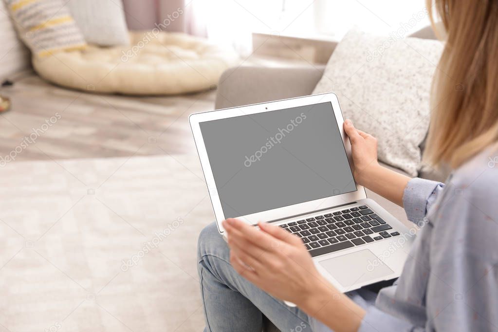Young woman using video chat on laptop in living room, closeup. Space for design