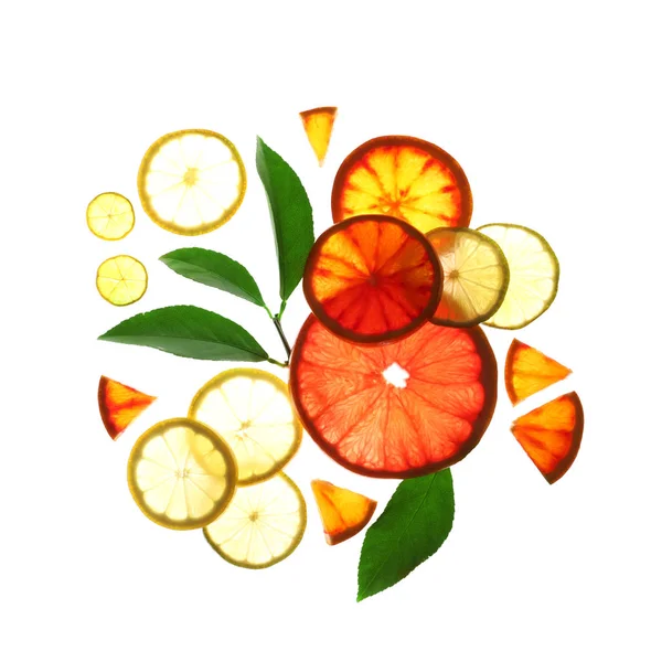Verlichte plakjes citrusvruchten en bladeren op witte achtergrond, bovenaanzicht — Stockfoto