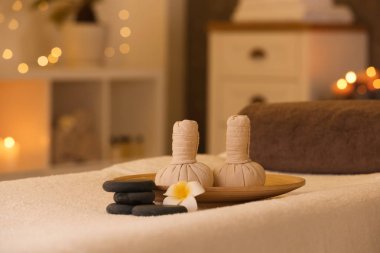 Spa salonunda masaj masasında bitkisel kompres ve taşlar
